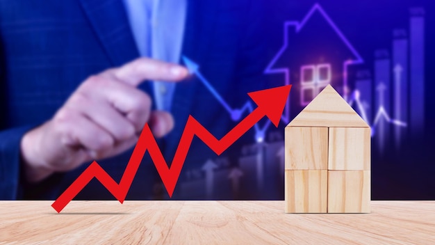 Foto uma seta vermelha para cima e uma casa de madeira o conceito do aumento do preço dos imóveis alta demanda por imóveis crescimento das taxas de aluguel e vendas de hipotecas de apartamentos a população cresce