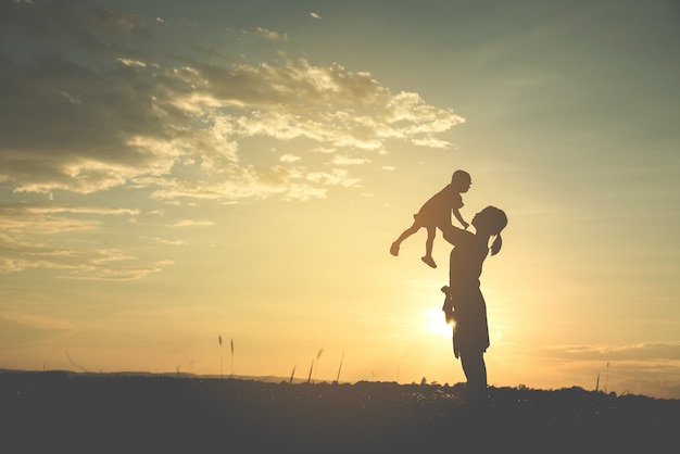 Uma silhueta de uma família harmoniosa da matriz nova feliz ao ar livre.