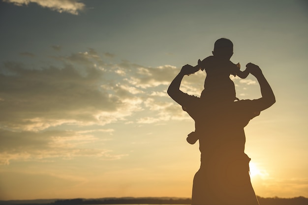 Uma silhueta de uma família harmoniosa da matriz nova feliz ao ar livre.