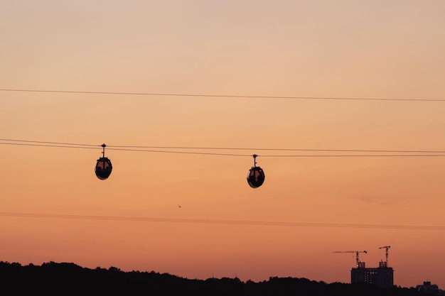 Uma silhueta do funicular contra o céu laranja do pôr do sol