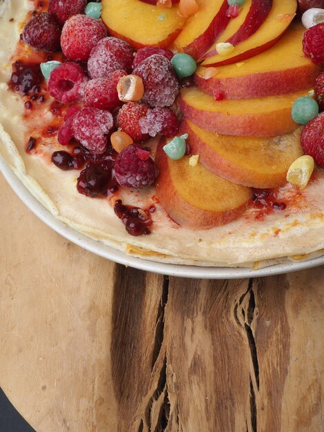 Uma sobremesa com frutas e um prato branco sobre uma mesa de madeira.