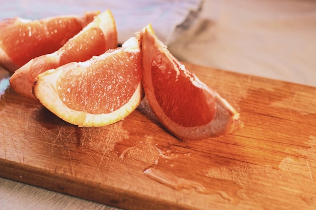 Uma tábua de corte de madeira com fatias de toranja.