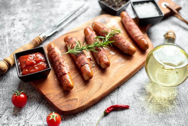 Uma tábua de corte de madeira com salsichas e um copo de vinho tinto.