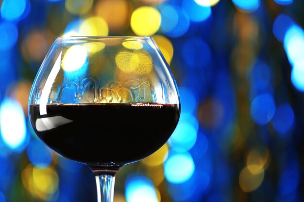 Uma taça de vinho tinto em uma superfície iluminada e embaçada