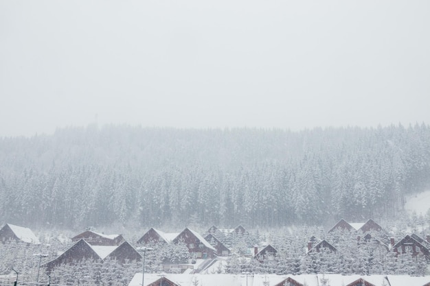 Foto uma tempestade de neve nas montanhas varre casas de madeira casas de madeira