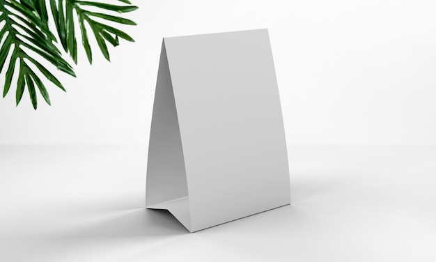 Foto uma tenda de mesa de papel branco renderizada em um ambiente elegante com folhas de plano verde e espaço para cópia