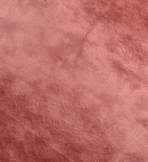 Uma textura de couro rosa com uma mancha preta na parte inferior.