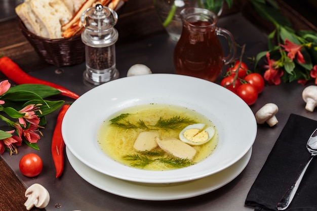 Uma tigela branca cheia de deliciosa sopa de macarrão de galinha