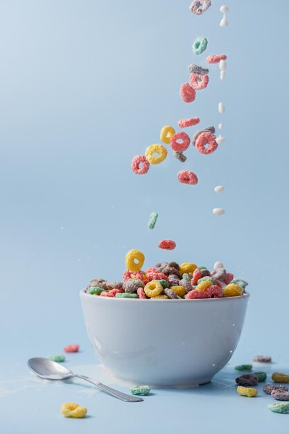 Foto uma tigela branca com cereais e leite em forma de anel colorido cereais e leite derramados na tigela