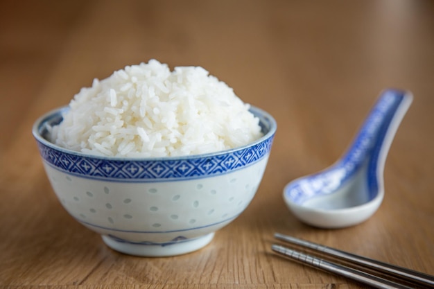 Uma tigela de arroz branco em fundo de madeira