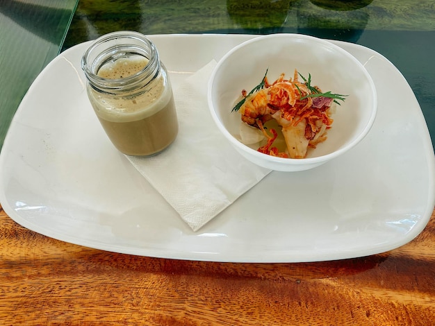 Uma tigela de camarão e um pote de molho em um prato