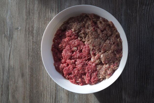 Uma tigela de carne e uma mistura de carne em uma mesa.