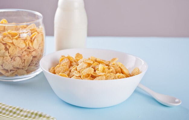 Uma tigela de cereal de flocos de milho seco em fundo azul