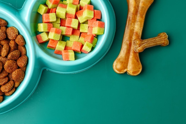 Uma tigela de comida seca para animais de estimação em fundo verde