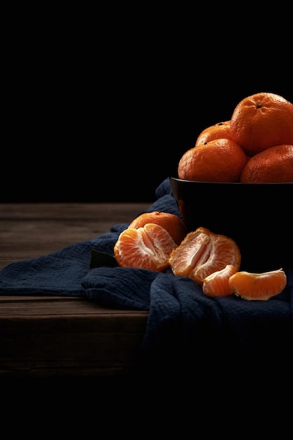 Foto uma tigela de laranjas está sobre uma mesa com um pano azul.