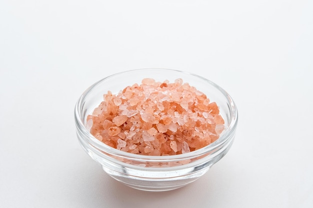 Uma tigela de sal rosa do Himalaia no espaço de cópia de mesa branca Foco selecionado