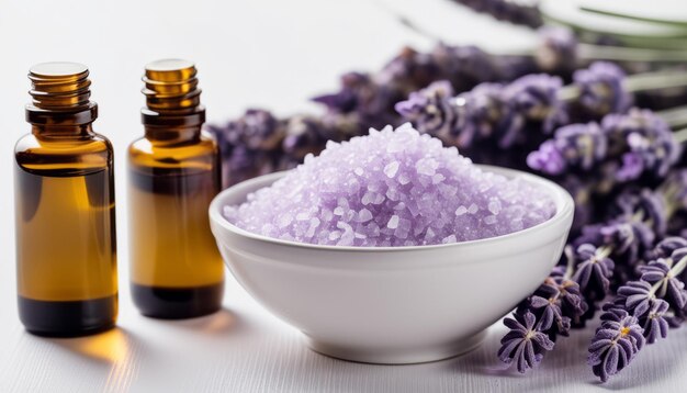 Uma tigela de sal roxo fica ao lado de duas garrafas de óleo de lavanda