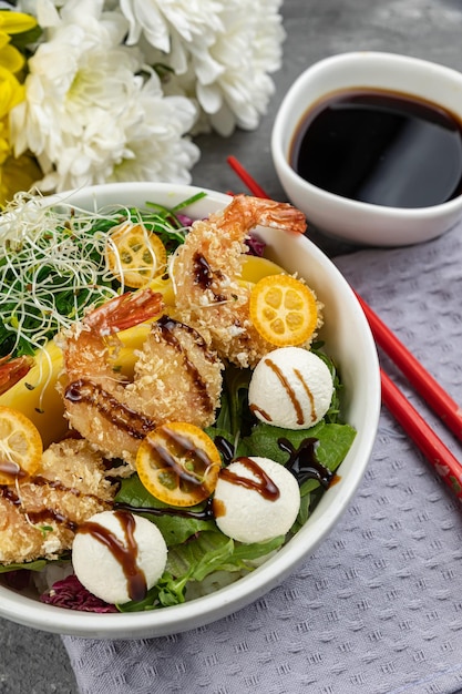 Uma tigela de salada de camarão com molho de soja e molho de soja.