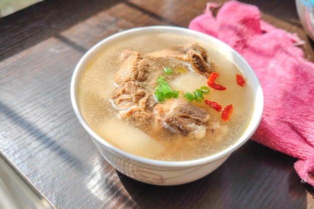 Uma tigela de sopa de costela de rabanete na mesa ao sol