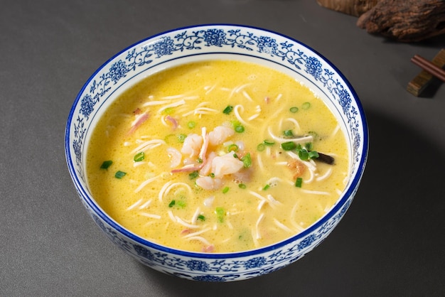 Uma tigela de sopa de macarrão vietnamita com uma borda azul.