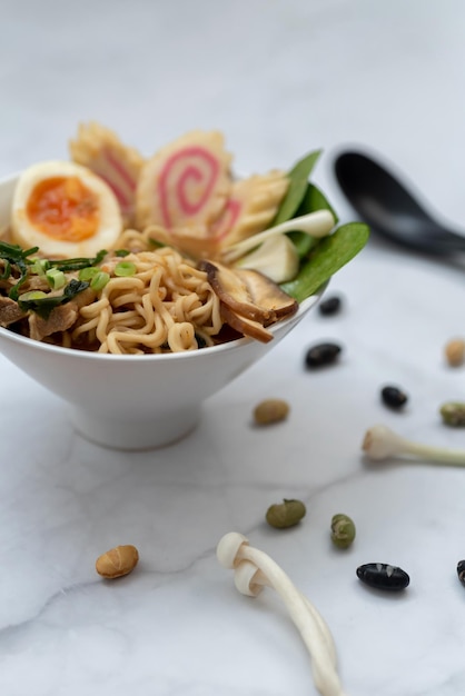 Uma tigela de sopa de ramen com todos os ingredientes sobre uma mesa de mármore