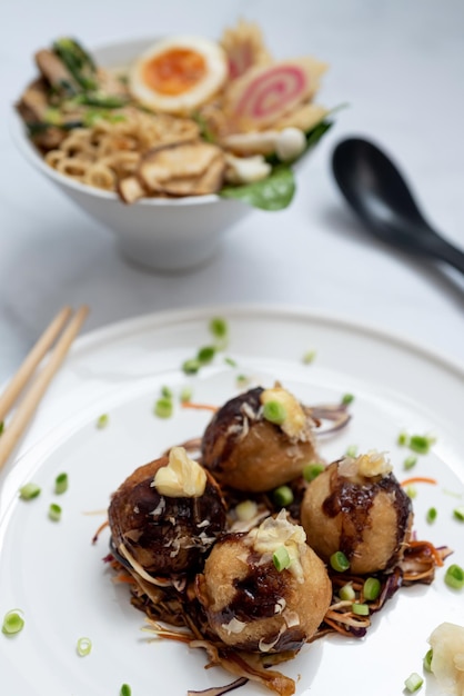 Uma tigela de sopa de Ramen e um prato de lanche Takoyaki