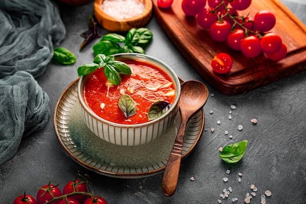 Uma tigela de sopa tradicional de tomate espanha com creme e manjericão na mesa, tomate e gazpacho de manjericão