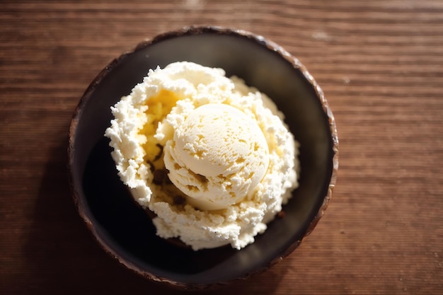 Uma tigela de sorvete de coco com uma colher de coco por cima.