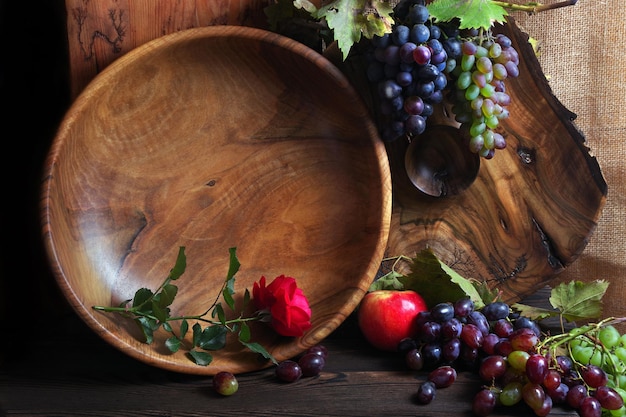 Uma tigela de uvas e uma flor vermelha