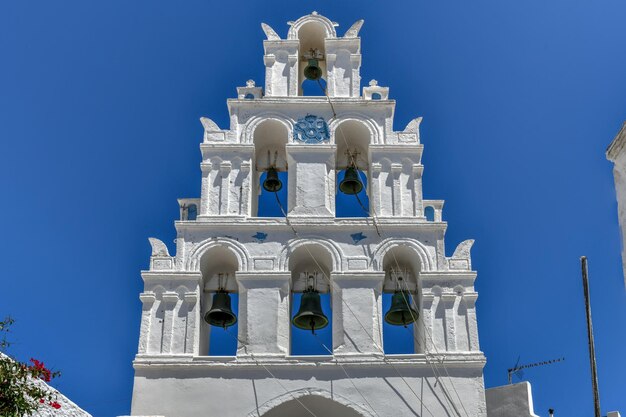 Foto uma típica rua de paralelepípedos com um campanário arqueado na tradicional aldeia de megalochori, em santorini, na grécia