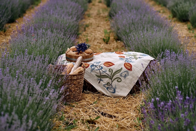 Uma toalha de mesa bordada fica no meio de um campo de lavanda.