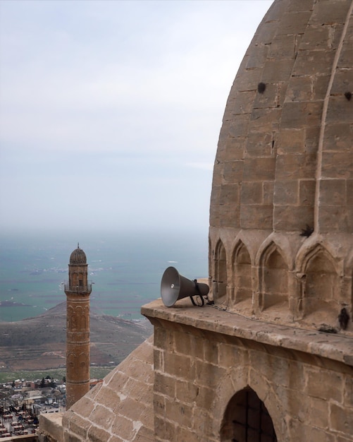 Foto uma torre de minarete de mesquita com campos verdes no fundo e um telhado de zinciriye medresesi