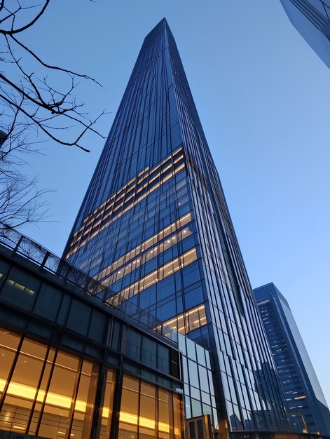 Uma torre de vidro e edifícios altos e iluminados