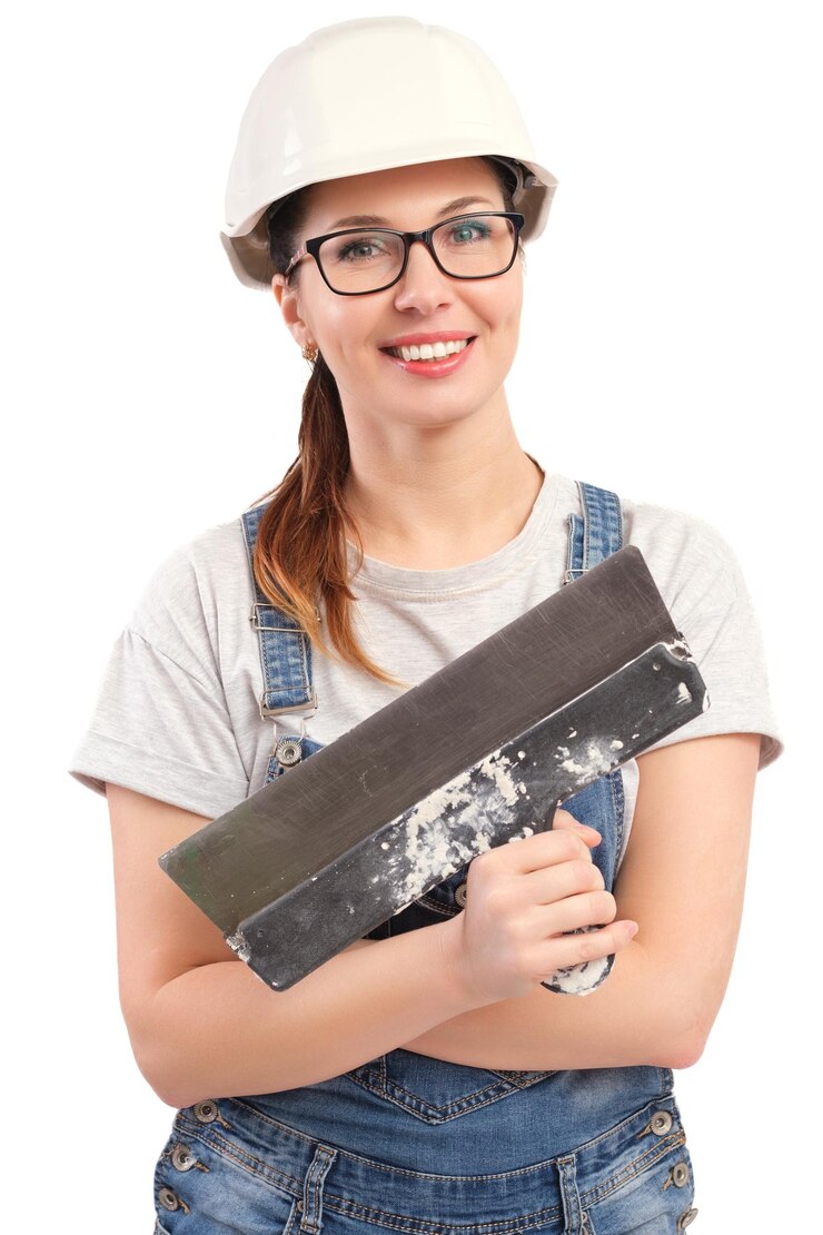 Foto uma trabalhadora de construção habilidosa com um sorriso amigável, usando um chapéu e óculos, segura com confiança uma pá de gesso pronta para o trabalho
