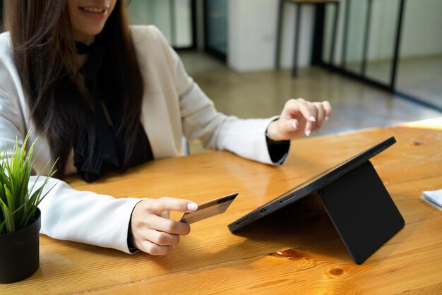 Uma trabalhadora de escritório ou empresária pagando despesas de cartão de crédito no computador tablet digital