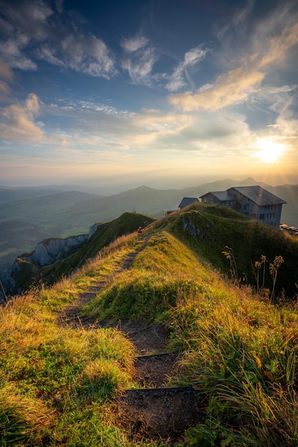 Uma trilha de caminhada em uma montanha levando a uma casa