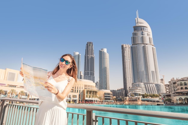 Foto uma turista feliz à procura de atrações no centro financeiro de negócios de uma cidade asiática com arranha-céus