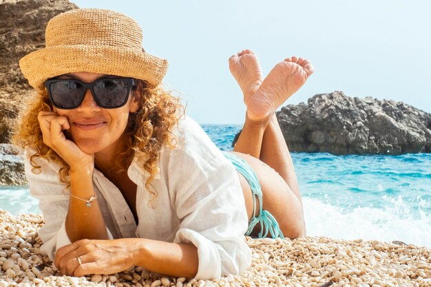 Uma turista mulher deitada na praia tropical desfrutando de férias ao ar livre atividade de lazer sozinha e usando chapéu de palha Pessoas e estilo de vida de férias de verão Sorriso feminino adulto em destino cênico