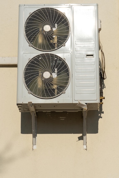 Uma unidade de ar condicionado externa composta por dois ventiladores Um grande ar condicionado industrial na parede de uma loja ou empresa Reparação e manutenção do sistema de ar condicionado