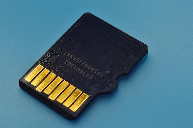 Uma unidade flash micro sd está em um fundo azul com os contatos voltados para cima