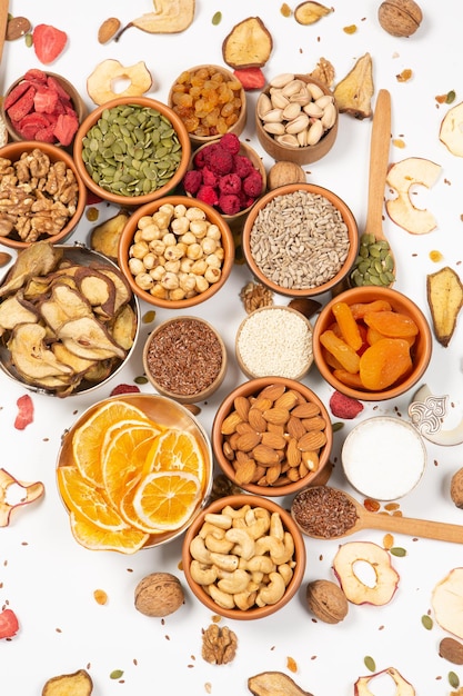 Uma variedade de alimentos, incluindo nozes, frutas, nozes e sementes, está sobre uma mesa.