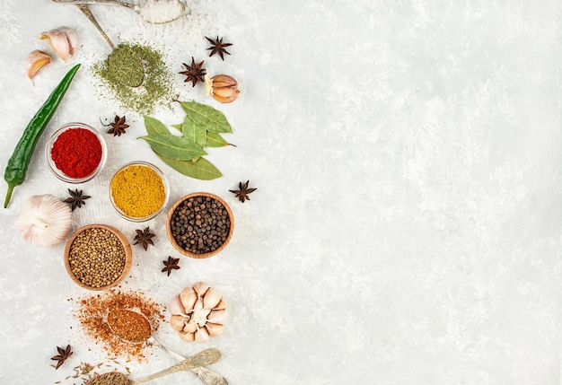 Uma variedade de especiarias e ervas em uma mesa de luz Preparando o fundo Vista de cima Ingredientes para cozinhar Menu de fundo da mesa