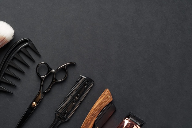 Foto uma variedade de ferramentas profissionais de cabeleireiro dispostas em uma superfície escura