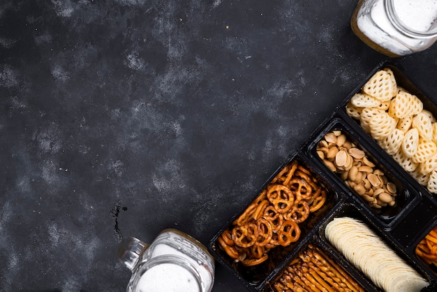 Uma variedade de lanches na caixa de cerveja em uma mesa preta concreta