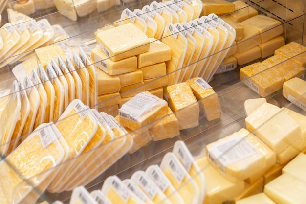 Uma variedade de queijos embalados em uma vitrine Produtos úteis e saudáveis Vista superior