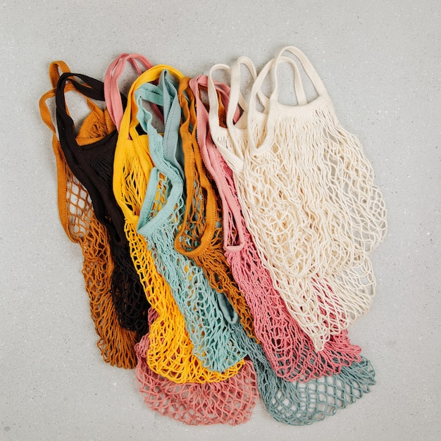 Uma variedade de sacolas de compras reutilizáveis coloridas. conceito de desperdício zero. sem plástico. sacos de malha ecológicos.
