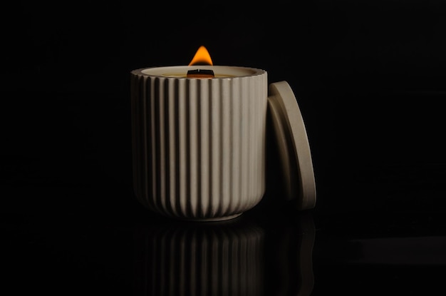 Foto uma vela num vaso de flores sobre um fundo preto