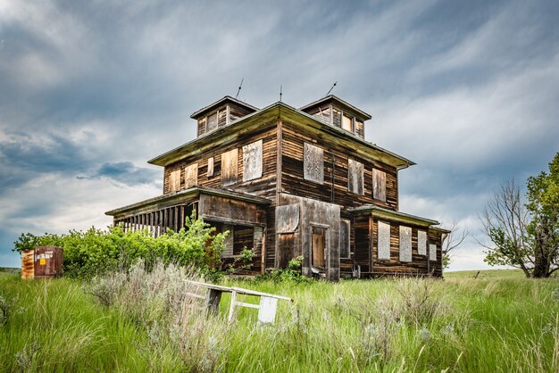 Uma velha casa abandonada nas pradarias de saskatchewan com um berço em primeiro plano