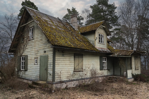 Foto uma velha casa de madeira abandonada ao lado do mar na floresta