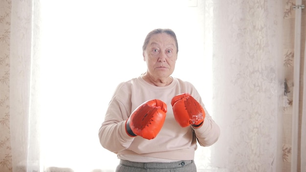 Uma velha em luvas de boxe está pronta para lutar